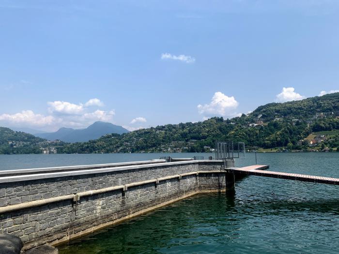 Molo di pietra su un lago con le colline sullo sfondo