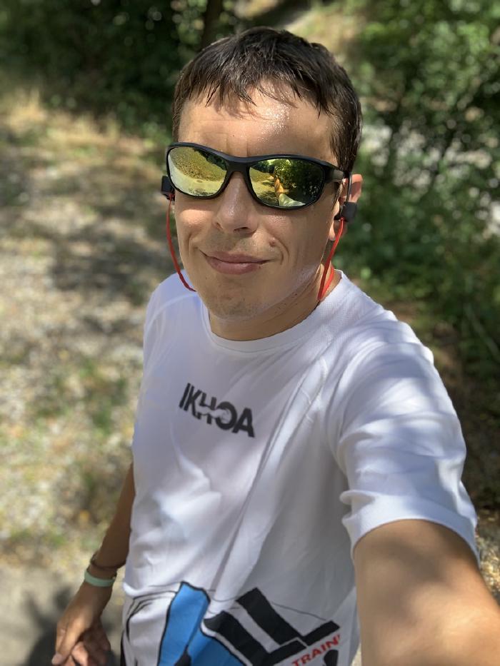 Selfie con occhiali da sole a specchio e maglietta bianca nel bosco
