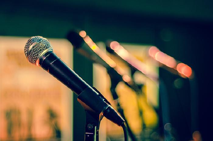 Microfono su un palco con le luci sfocate sullo sfondo
